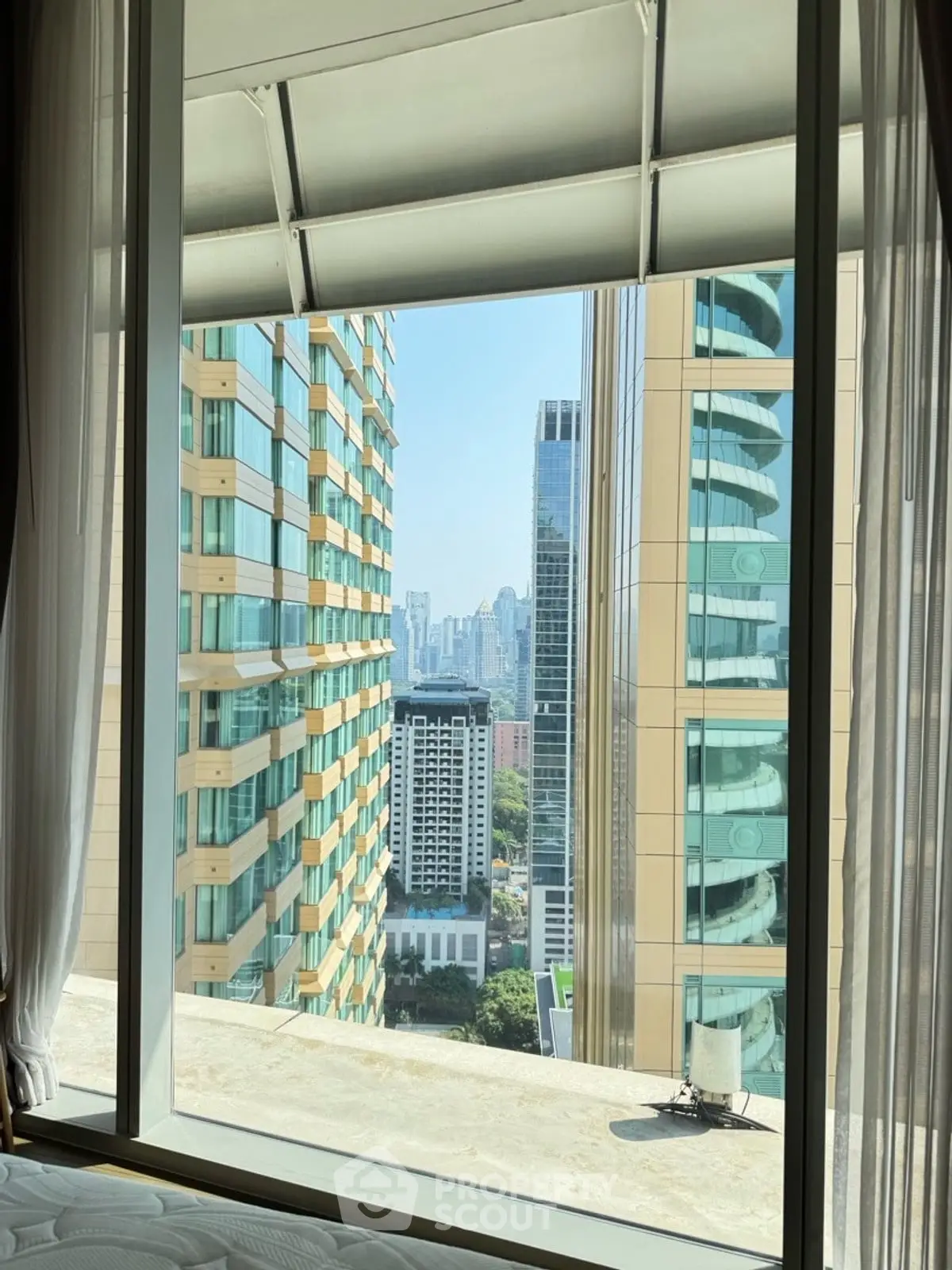 Stunning cityscape view from a high-rise apartment window, showcasing modern architecture and urban skyline.