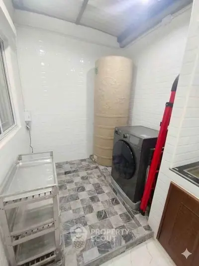 Modern laundry room with washing machine and storage space in a stylish home.