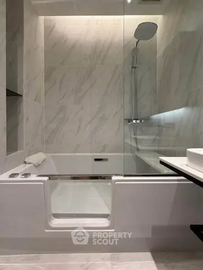Luxurious modern bathroom with sleek marble tiles and elegant fixtures.
