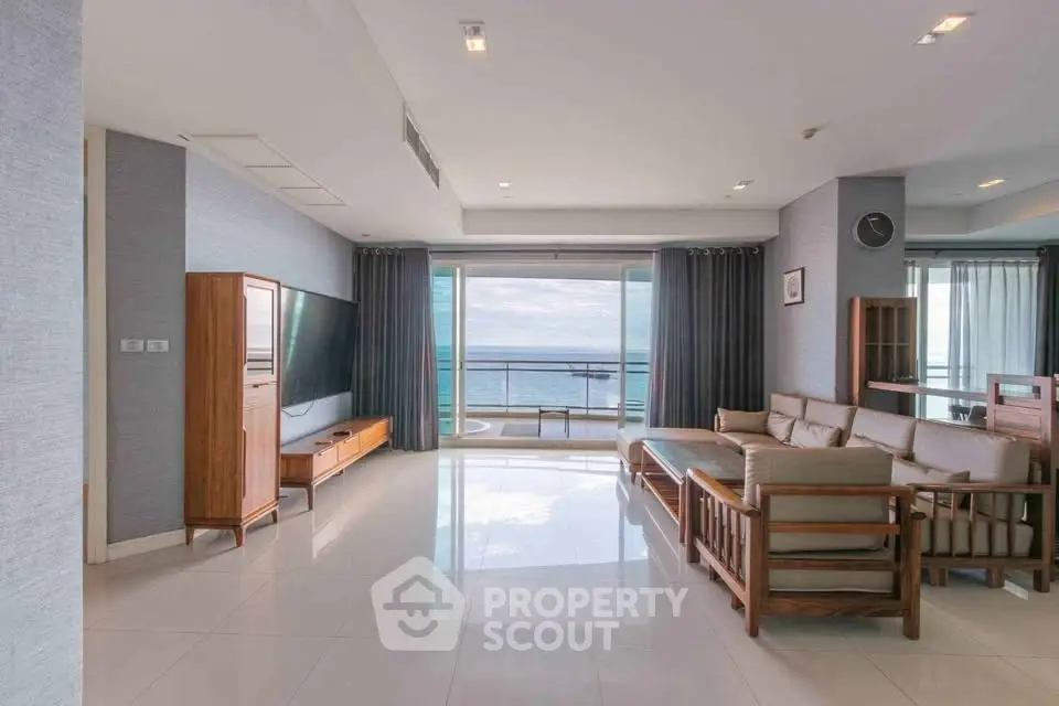 Spacious living room with ocean view and modern furniture in luxury apartment.