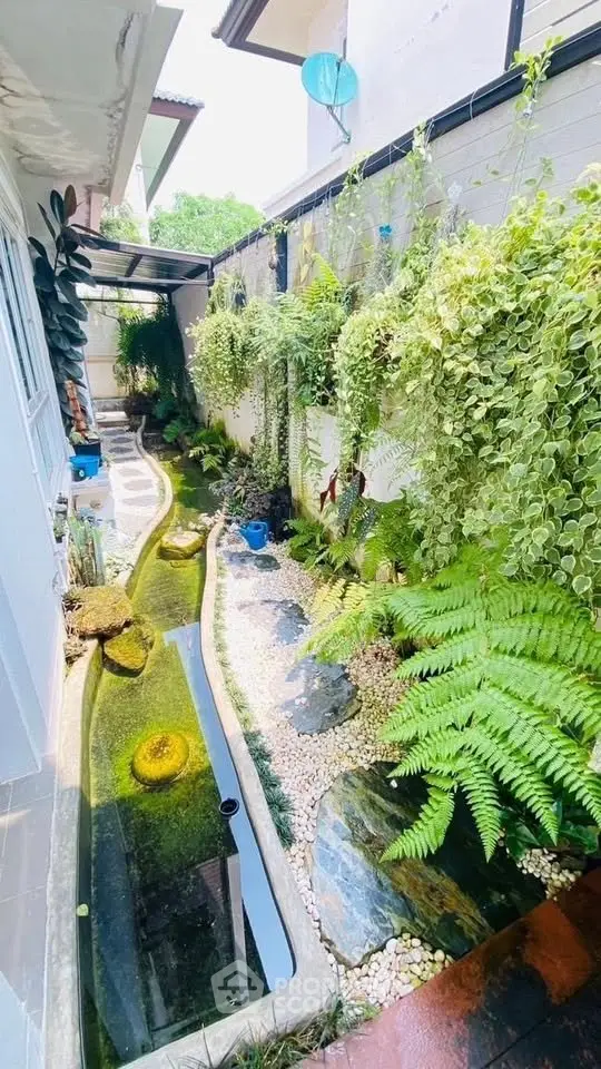 Stunning garden with lush greenery and water feature in modern home exterior
