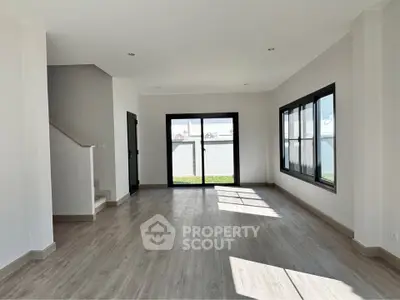 Spacious modern living room with large windows and wooden flooring