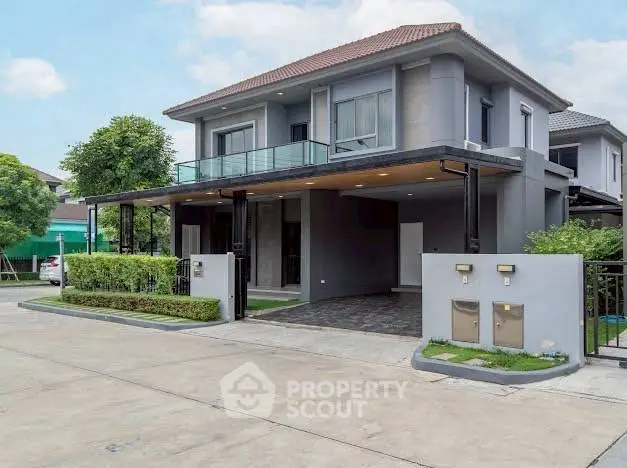 Modern two-story house with spacious driveway and stylish balcony in suburban neighborhood.
