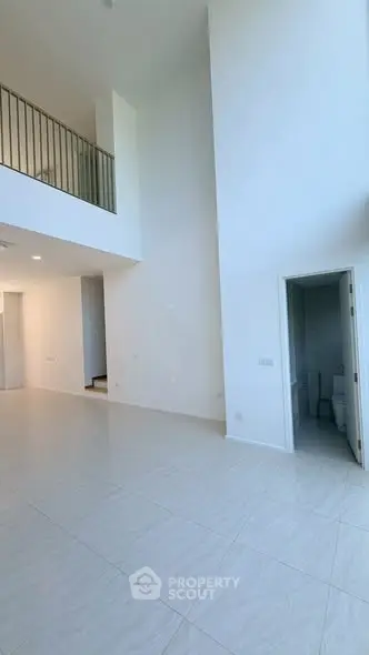 Spacious modern living room with high ceilings and elegant staircase