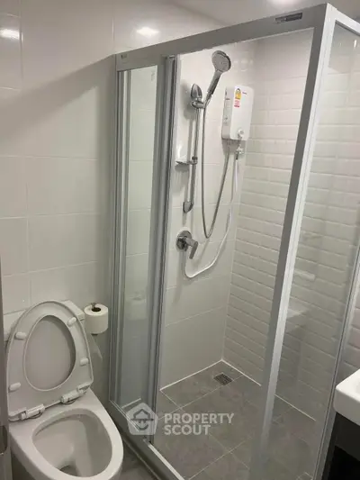 Modern bathroom with glass shower enclosure and sleek fixtures in a contemporary apartment.