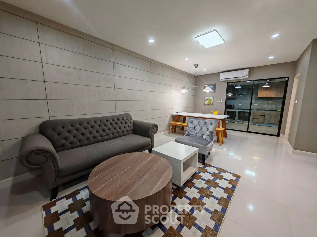 Modern living room with stylish furniture and open kitchen layout in a contemporary apartment.