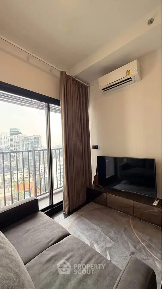 Modern living room with city view, featuring sleek furniture and air conditioning, perfect for urban living.