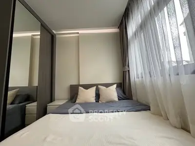 Cozy bedroom with modern decor and large window for natural light.