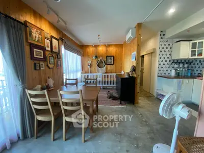 Charming open-layout living space with dining area and stylish kitchen, featuring wooden accents and cozy decor.