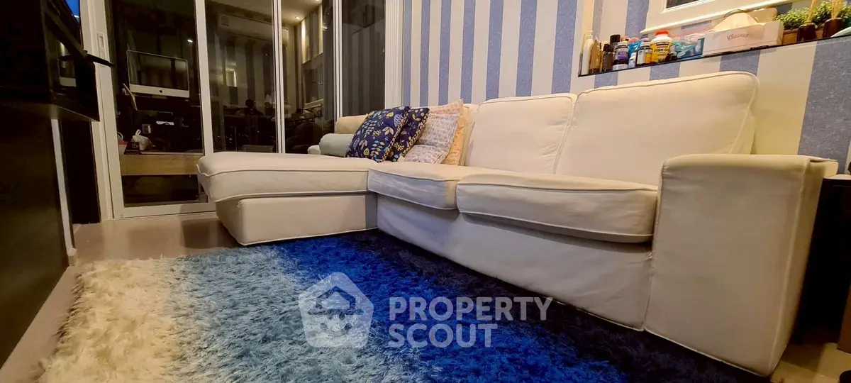 Cozy living room with plush white sofa and vibrant blue rug