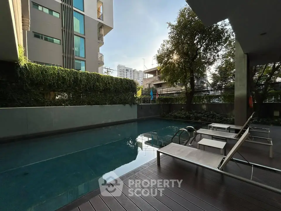 Luxurious apartment pool area with modern design and lush greenery