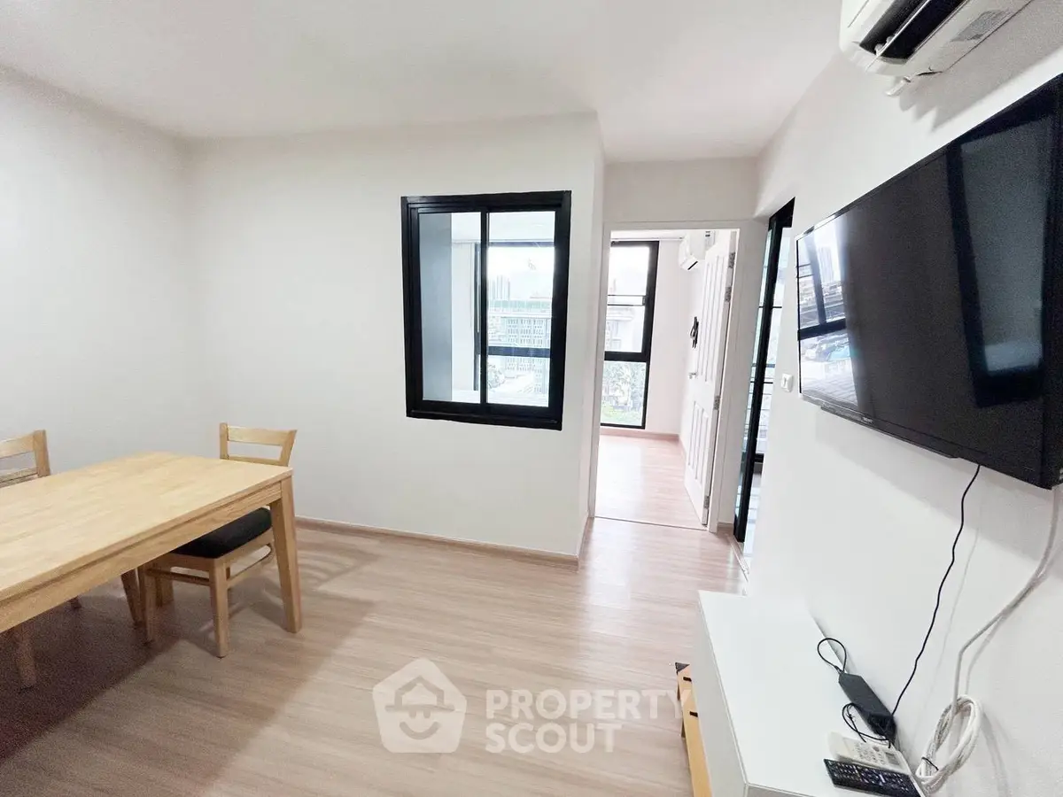 Modern living room with wooden flooring and wall-mounted TV