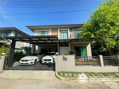 Modern two-story house with spacious driveway and lush greenery