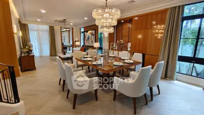 Luxurious dining room with elegant chandelier and modern decor in a spacious open layout.