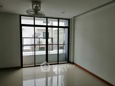 Spacious room with large windows and balcony access in modern apartment