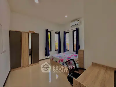 Spacious bedroom with modern furniture and natural light