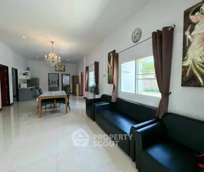 Spacious living room with elegant chandelier and modern decor in a bright open layout.