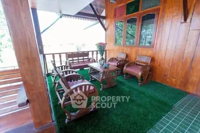 Charming wooden balcony with cozy seating and lush green flooring