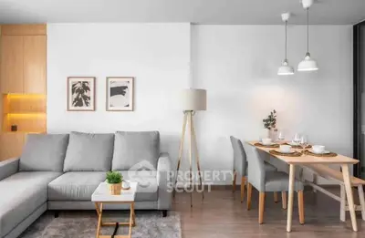 Modern living room with cozy gray sofa and elegant dining area in stylish apartment.