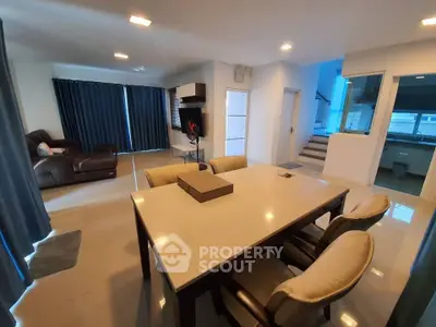 Spacious modern living and dining area with elegant furniture and natural light.