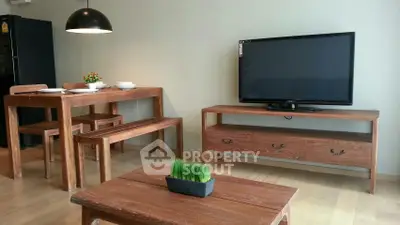 Modern living room with wooden furniture and flat-screen TV, perfect for cozy gatherings.
