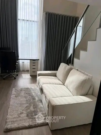 Modern living room with stylish sofa and elegant decor in a bright, airy space.