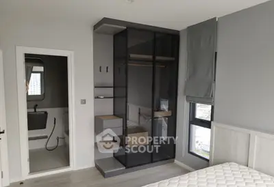 Modern bedroom with sleek wardrobe and ensuite bathroom in a stylish apartment.