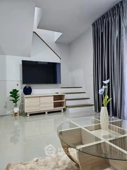 Modern living room with sleek design, large TV, and stylish decor in a contemporary home.