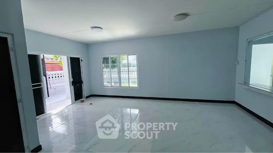 Spacious living room with large windows and modern lighting in a bright, airy home.