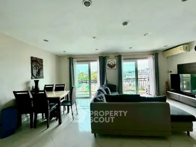 Spacious living room with modern furniture and balcony view, perfect for relaxation.