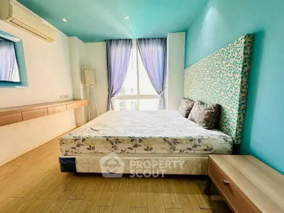 Spacious bedroom with modern decor and large window for natural light