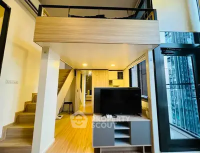 Modern loft apartment with mezzanine, stylish interior, and large windows offering city views.
