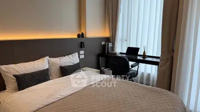Modern bedroom with cozy bed and stylish study area, featuring elegant decor and natural light.