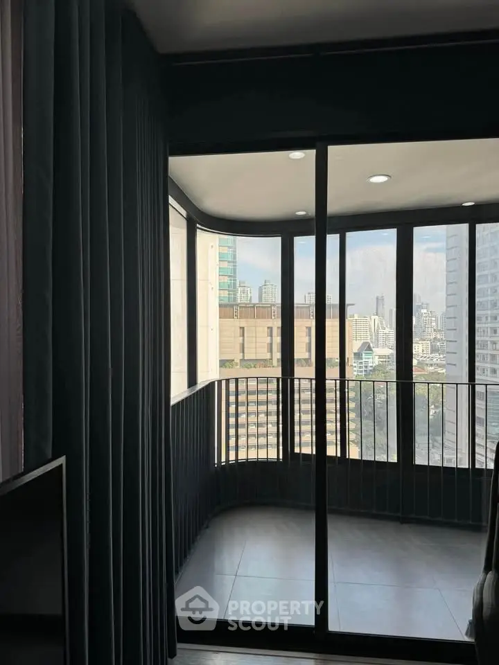 Modern apartment with floor-to-ceiling windows offering stunning city views and ample natural light.
