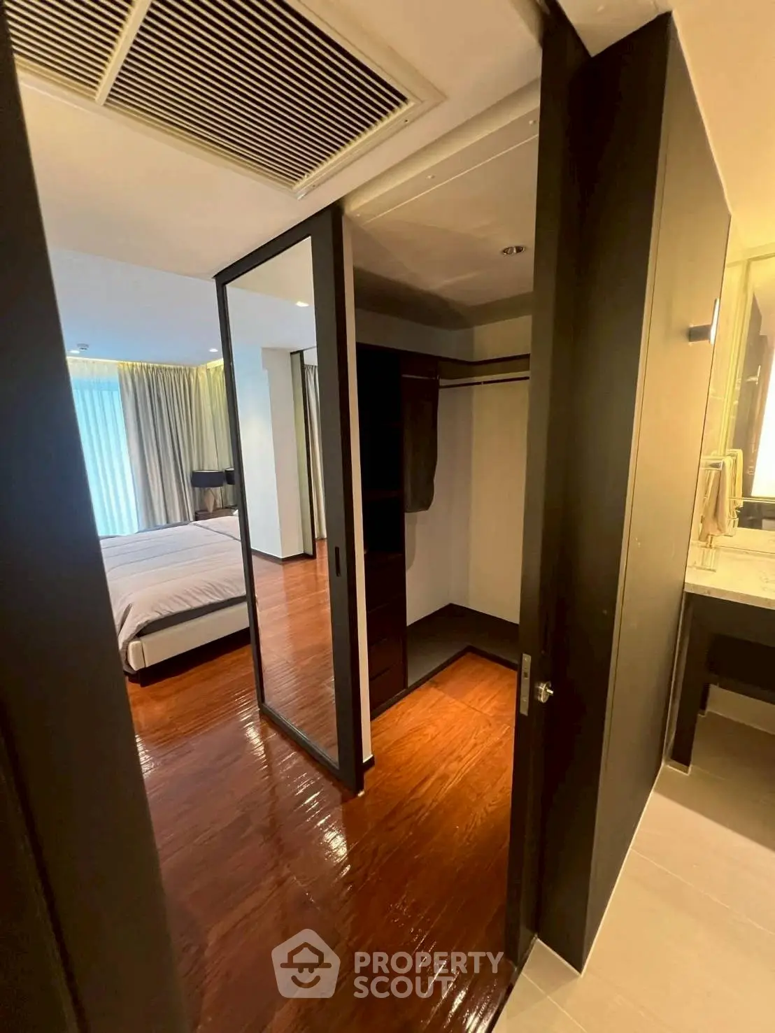 Spacious bedroom with walk-in closet and elegant wooden flooring