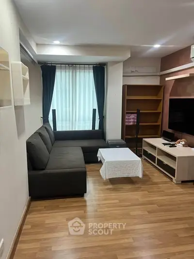 Cozy living room with modern sofa and entertainment center, perfect for relaxation.