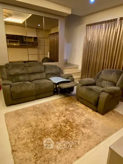 Cozy living room with plush sofas and elegant decor, perfect for relaxation and entertainment.