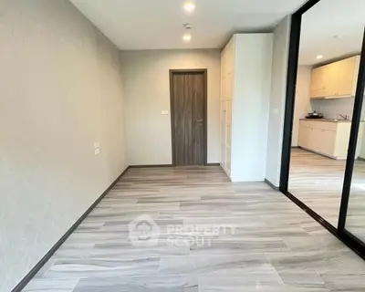 Spacious modern apartment interior with sleek flooring and ample natural light, perfect for stylish living.