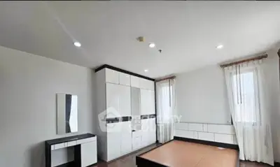 Spacious modern bedroom with sleek furniture and ample natural light.