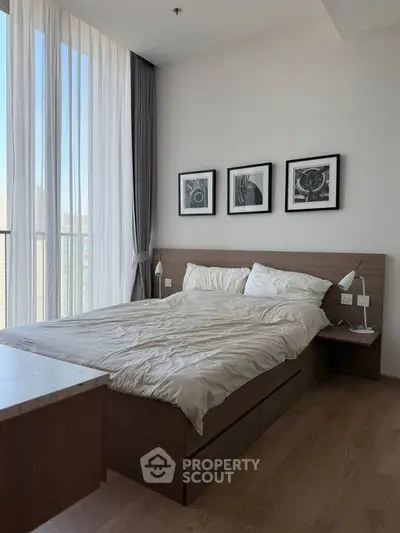 Modern bedroom with stylish decor and large window offering natural light