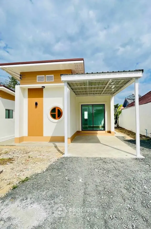Modern single-story house with unique circular window and covered carport, ideal for contemporary living.