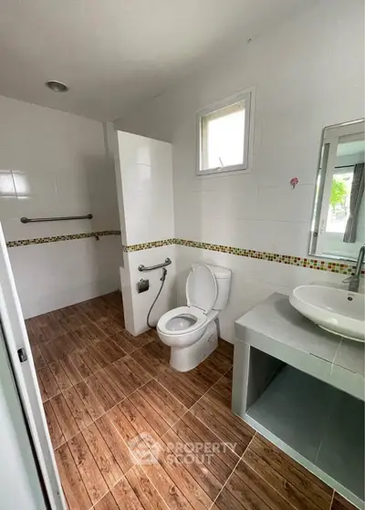 Modern bathroom with wooden floor tiles and sleek fixtures