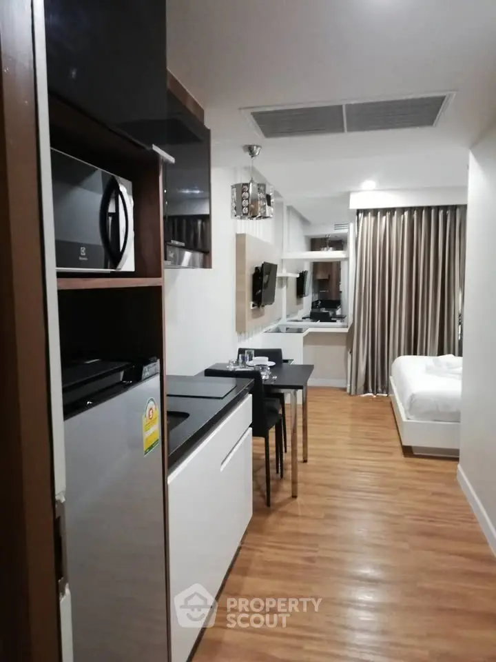 Modern studio apartment with sleek kitchen and cozy living area, perfect for urban living.