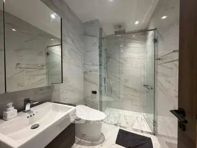 Luxurious modern bathroom with marble tiles and glass shower enclosure
