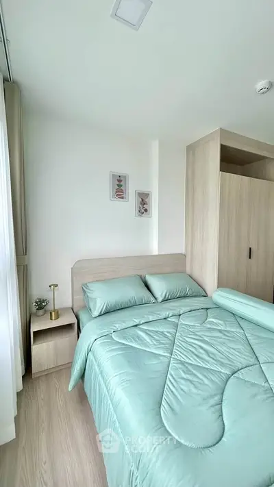 Modern bedroom with stylish decor and light wood furniture, featuring a cozy bed and elegant wall art.