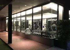 Modern gym with large glass windows in a luxury residential building.