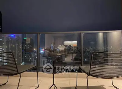 Stunning city view from a high-rise balcony with modern seating, perfect for urban living.