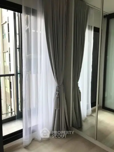 Elegant bedroom corner with floor-to-ceiling windows and luxurious curtains