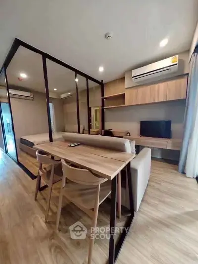 Modern living room with stylish furniture and open layout, featuring wood accents and air conditioning.
