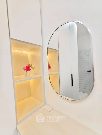 Modern bathroom vanity with oval mirror and built-in shelving